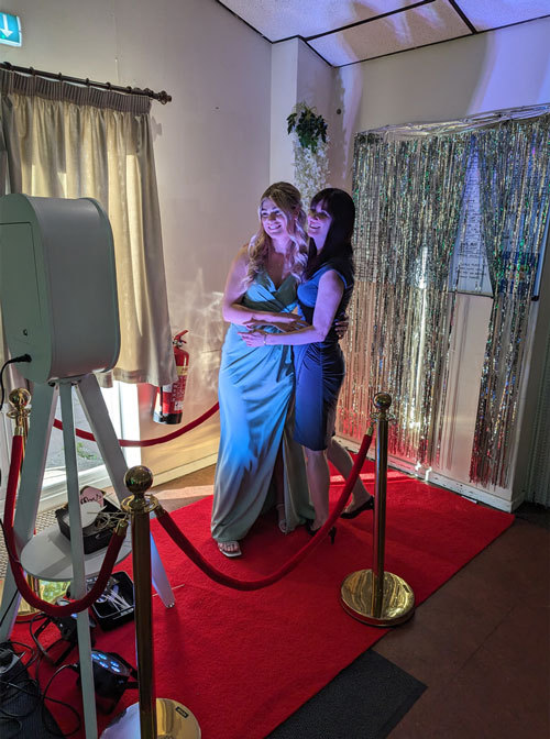 White vintage selfie pod with a ring light set up beside the dance floor at a wedding reception
