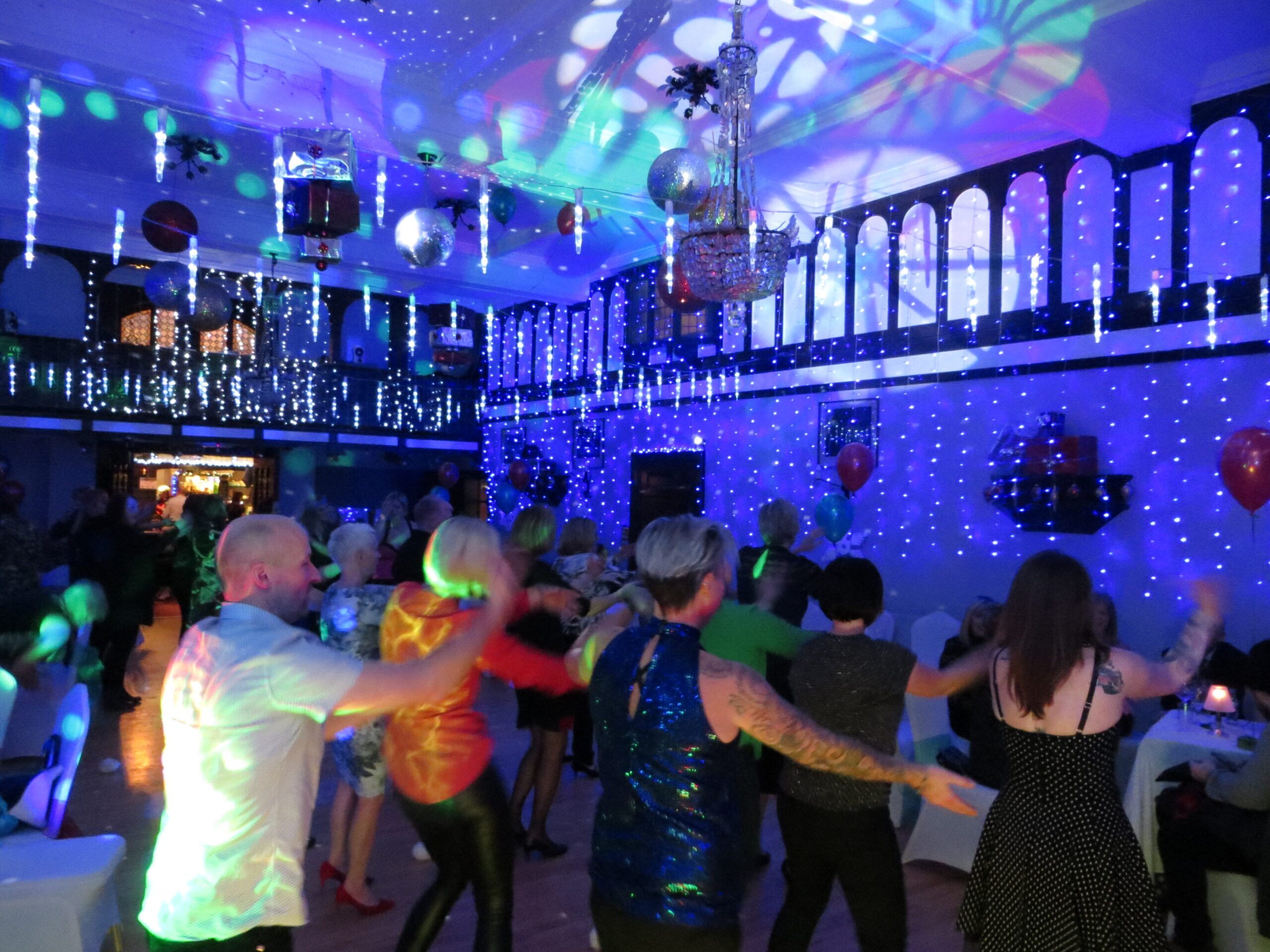 Three generations of one family dancing together at a 50th anniversary party in Norfolk